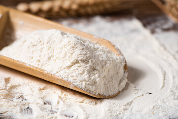 wheat flour and wheat ears on wooden table
