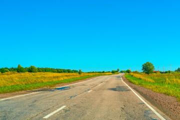 bad broken asphalt road rural on a sunny day