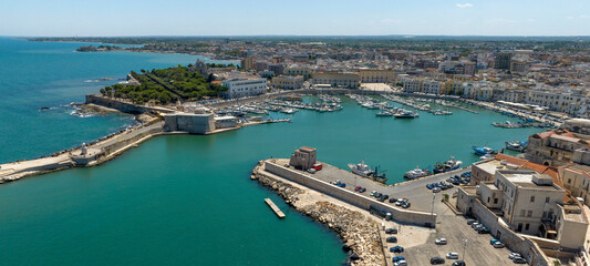 Fototapeta premium Aerial view of the port of the city of Trani, in Puglia, Italy. It is a small tourist seaport on the Adriatic Sea. There are many boats anchored in the clean water of the harbour.