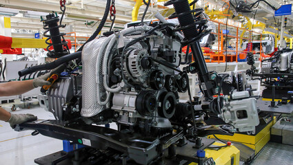 Assembly line process of engine manufacturing in a modern automotive factory during daytime operations