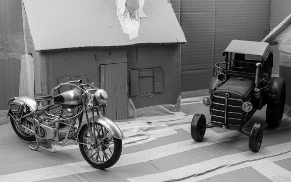 Historisch, Oldtimer, Motorrad Model, &auml;hnlich einer Harley Davidson und Traktor Model in Karton Modell-Landschaft in Schwarz Weiss