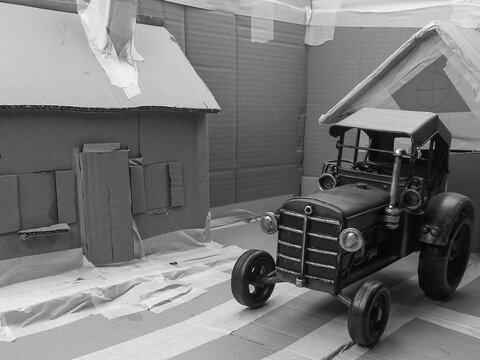 Historisch, Oldtimer, Spielzeug Traktor Modell in Karton Modell-Landschaft in Schwarz Weiss