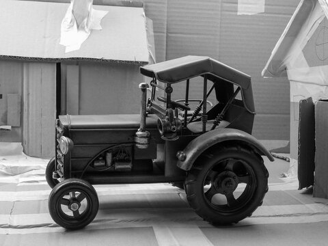 Historisch, Oldtimer, Spielzeug Traktor Modell in Karton Modell-Landschaft in Schwarz Weiss