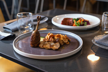 Gourmet duck leg confit restaurant plate luxury dining fine cuisine elegant presentation dinner...