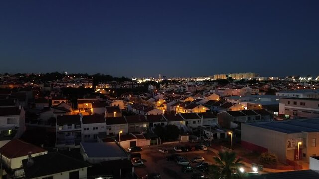 Drone panorama over the night town. Light in the windows of houses and yards.