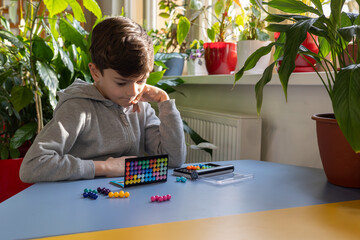 young boy engaged in a logical board game, fostering child development, intellectual growth, and mental well-being in a supportive, inclusive environment. Focus on psychology, therapy, and early lear