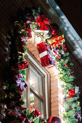 Christmas tree toys and fir branches decorate the window at night. New Year mood