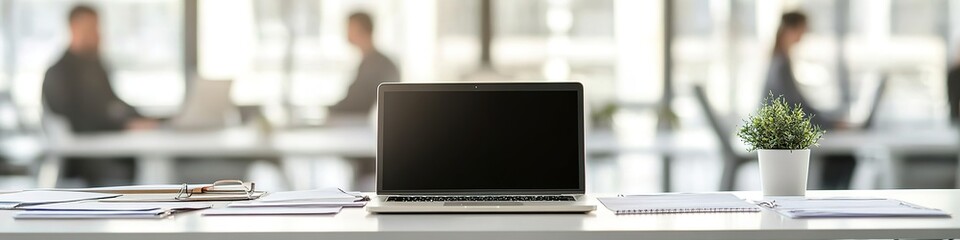 Fototapeta premium Laptop on desk in modern office space with blurred background