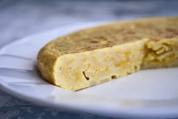 Juicy Spanish omelette made with eggs, potato and onion on a plate. Typical tapas of Spanish cuisine.