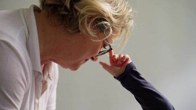 Touching moment between a pediatrician and a young child, reminiscent of a grandmother and grandchild bond, as the child reaches out to her glasses. Concept of care, warmth, and trust in healthcare