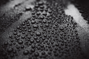 Closeup black car paint surface with hydrophobic ceramic coating