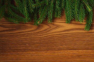 Christmas background with spruce branches on wood board top view with copy space