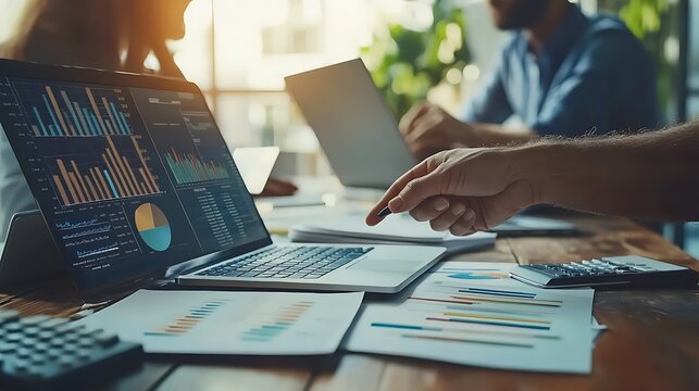 A business team analyzing financial data on laptop, Business team analyzing financial