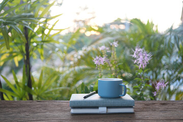 blue cup and notebooks on wooden table