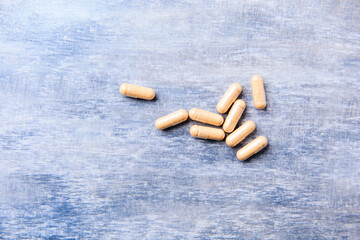 Lutein capsules. Dietary supplement on wooden background. Soft focus. Top view. Close up. Copy...