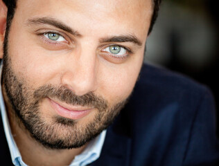 Portrait of a confident businessman smiling slightly and showing his beautiful green eyes