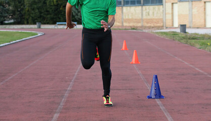 Athlete running on track with cones performing agility exercises