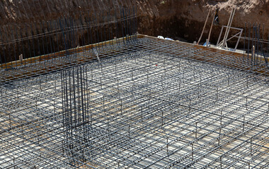 Steel rebar grid forming foundation structure at construction site