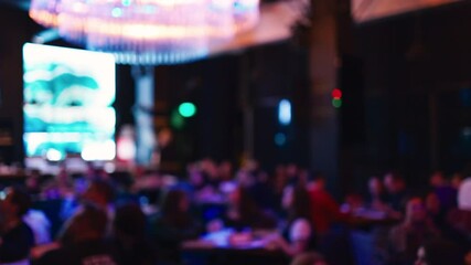 The image displays a softly blurry background that beautifully highlights the vibrant atmosphere of a busy indoor venue