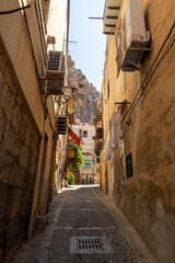 Narrow street in the old town of Cefalu in Sicily, Italy in a beautiful summer day. Travel and sightseeing journey concept