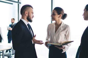 Young colleagues discussing work in office