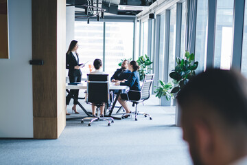 Colleagues working near office of boss