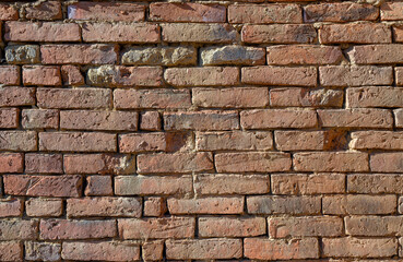 Background with old wall made with handmade brick made out of clay.