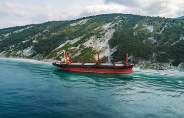 Obraz premium Aerial view of an abandoned bulk-carrier dry cargo ship washed ashore after a storm