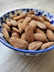 Natural roasted brown almonds in a decorative plate 