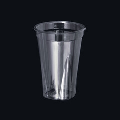 Photo of a disposable clear plastic cup on a dark background. Subject photography.