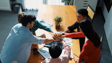 Top view of happy creative team putting hands together while drawing mind map. Group of diverse people working together brainstorming marketing idea and sharing plan by using sticky notes. Convocation