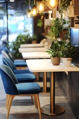 Fototapeta premium A modern cafe interior with blue velvet chairs, a white table, and gold accents