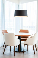 Modern dining area with stylish chairs and a pendant lamp in a bright space