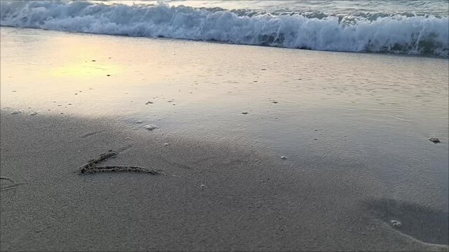 2024 written on the beach and waves hitting the shore. bye bye 2024, welcome 2025