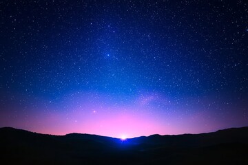 Fototapeta premium Starlit sky over mountains at twilight with vibrant colors on the horizon