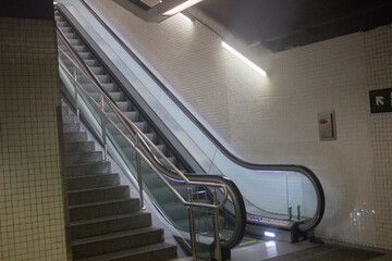 empty escalator in a metro station; underground descent into the metro to the train.