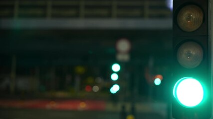 Close-up of a traffic light at night, changing from red to green.