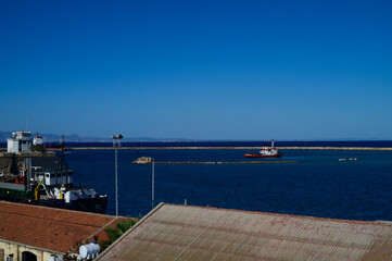 Obraz premium A serene harbor view at midday with boats resting in calm waters under a clear blue sky