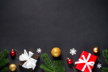 Black christmas flat lay background. Christmas fir tree with presents and holidays decorations.