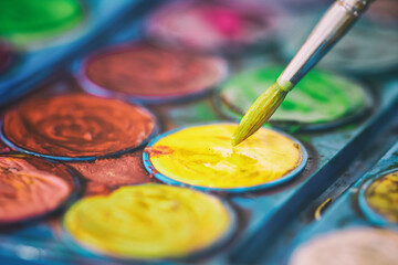 Brush in watercolors. painter dipping the brush to paint.
