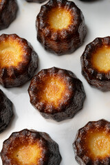 Caneles de bordeaux, traditional French sweet dessert with white table background, High quality photo