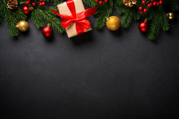 Black christmas flat lay background. Christmas tree with present box and holidays decorations at black.