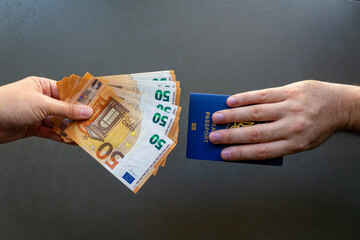 Person Holding Money and Another Holding Passport. One person holding money while another holds a...
