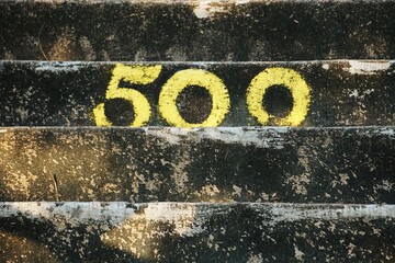 Cyfra 500 namalowana na schodach. Schody i widoczny z bliska napis 500.  © Adam