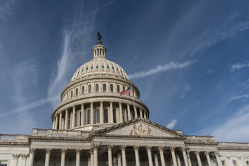 Fototapeta premium American Flag Flies over the United States Capitol Building in Washington DC