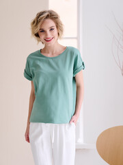 Pregnant girl model in casual clothing, photographing in the studio on a light background.