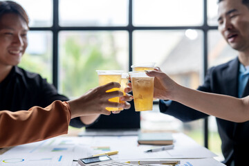 Business people toasting with beer after corporate meeting