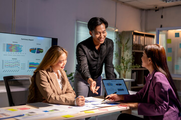 Asian business team working late and brainstorming using data on laptop