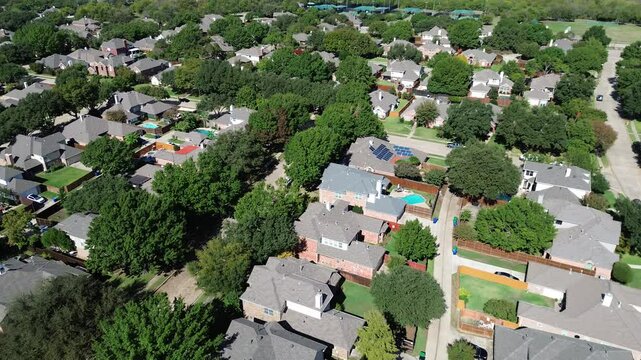 Solar roof panels on new construction two-story houses in upscale residential area with tennis courts complex, well-trimmed lawn landscape, Carrollton, suburbs Dallas Fort Worth metroplex, flyover