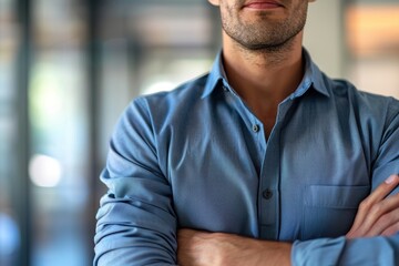 Obraz premium Professional portrait of a man confidently crossing his arms, representing success and leadership while collaborating on a new project with a positive demeanor